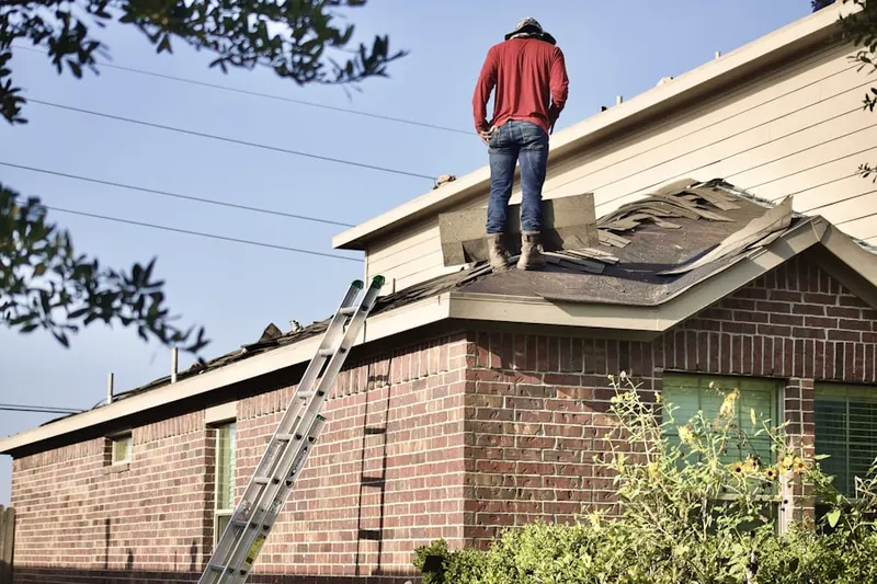 Professional roofer working on a residential roof in Wellesley Hills